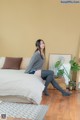 A woman sitting on a bed in a bedroom.